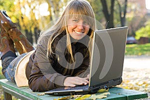 Young woman working with laptop in city park