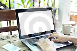 Young  woman working  laptop computer on wood desk in coffee shop.,Empty notebook