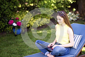 Young woman working on laptop in the garden