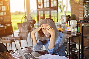 Young woman working on laptop having a headache.