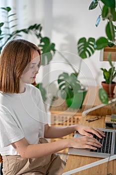 Young woman working on laptop from home.