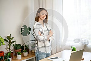 Young woman working on laptop at home. Cozy home office workplace, remote work, e-learning concept.