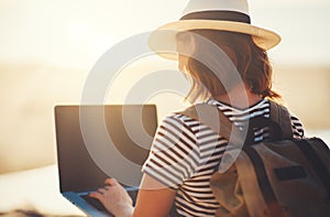 Young woman working with laptop on nature in beach