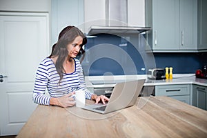 Young woman working on laptop while sitting at table