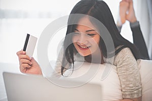 Young woman working on a laptop and uses credit card, bussiness and shopping concept