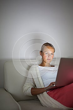 Young woman working late at night on her laptop computer