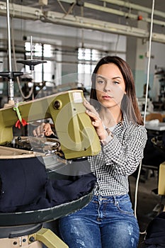 young woman working with linking machine for knitting in textile industry