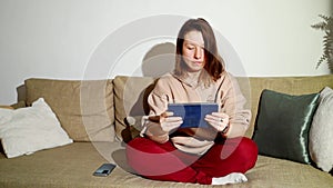 Young woman working at living room. Home vacation sofa portrait. Blogger video