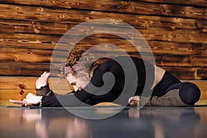 Young woman working out doing yoga or pilates exercise sitting in Janu Sirsasana