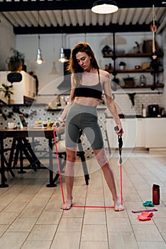 Young woman working out at home with an resistance band