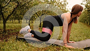 young woman working out Resistance bands in sportswear outdoors