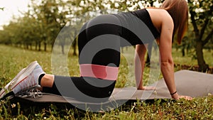 young woman working out Resistance bands in sportswear outdoors