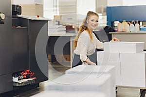 Young woman working in printing factory. Printing Press.