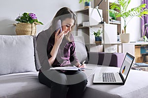 Young woman working remotely at home, business female freelancer