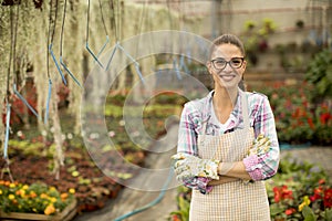 Young woman working with spring flowers in the greenhouse