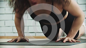 Young woman on workout doing push ups from her knees