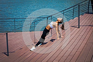 Young woman workout outdoor in the city promenade along the rive