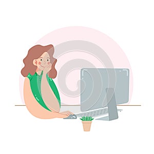 Young woman works at the computer. Freelancer or office worker sitting with computer and flower in a pot