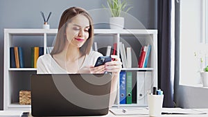 Young Woman Works at Home Office Using Computer and Smertphone. Workplace of Female Entrepreneur, Freelancer or Student