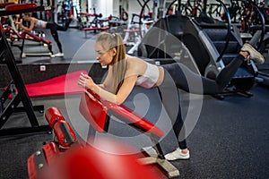 Young woman works out in the gym performing an exercise