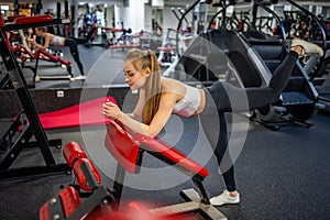 Young woman works out in the gym performing an exercise
