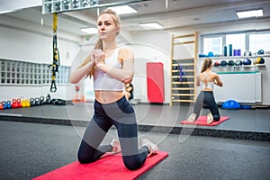 Young woman works out in the gym performing an exercise