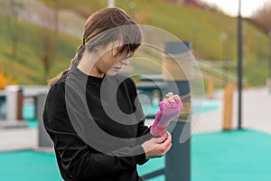 Young woman wrapping a wrist wrap around her hand before outdoor martial arts training