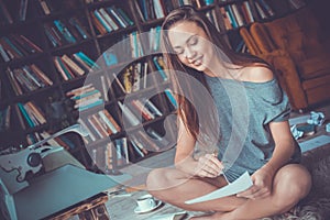 Young woman writer in library at home creative occupation checking grammar