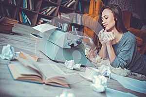 Young woman writer in library at home creative occupation crumpling paper close-up