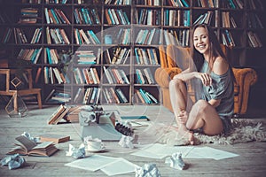 Young woman writer in library at home creative occupation laughing