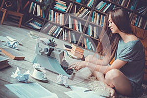 Young woman writer in library at home creative occupation pressing buttons