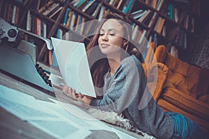 Young woman writer in library at home creative occupation reading page