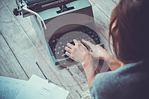 Young woman writer in library at home creative occupation typing typewriter