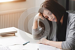 Young woman with writer's block sitting at desk