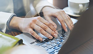 Young woman writes hands a text message on laptop keyboard with a empty blank screen monitor while having recreation time at home