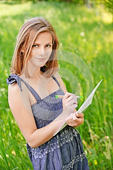 Young woman writes on sheet of paper