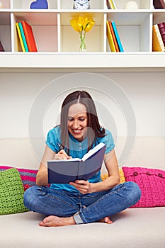 Young woman writing something in datebook