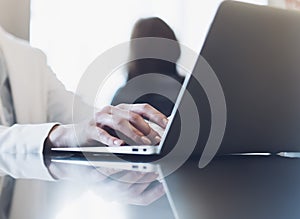 Young woman writing text hands on the open laptop in a cafe on a table with reflection, businesswoman working on computer