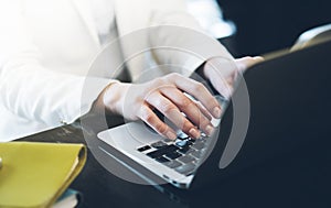 Young woman writing text hands on the open laptop in a cafe on a table with reflection, businesswoman working on computer