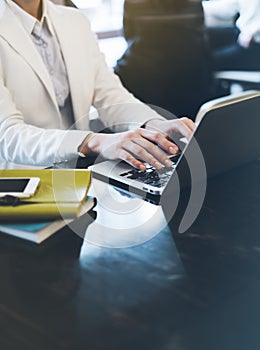 Young woman writing text hands on the open laptop in a cafe on a table with reflection and glare , businesswoman working on comput