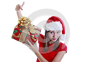 Young woman with xmas hat pointing at present