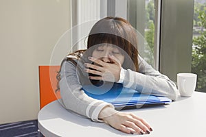 Young woman yawing in office