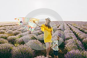 Young woman in yellow dress walk on purple lavender flower meadow field background, rest, have fun, play with kite