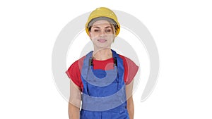 Young woman in yellow hardhat walking on white background.