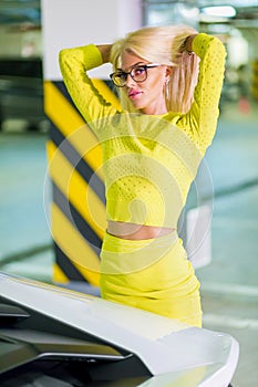 Young woman in yellow suit rearrange hair standing photo