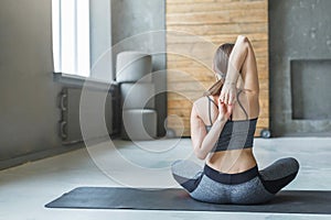 Young woman in yoga class, back stretching