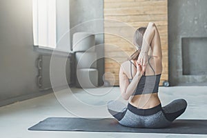 Young woman in yoga class, back stretching