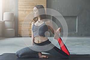 Young woman in yoga class, mermaid pose asana