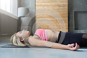 Young woman in yoga class, relax meditation corpse pose