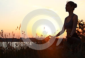 Young woman  yoga outdoors on sunset. Zen meditation